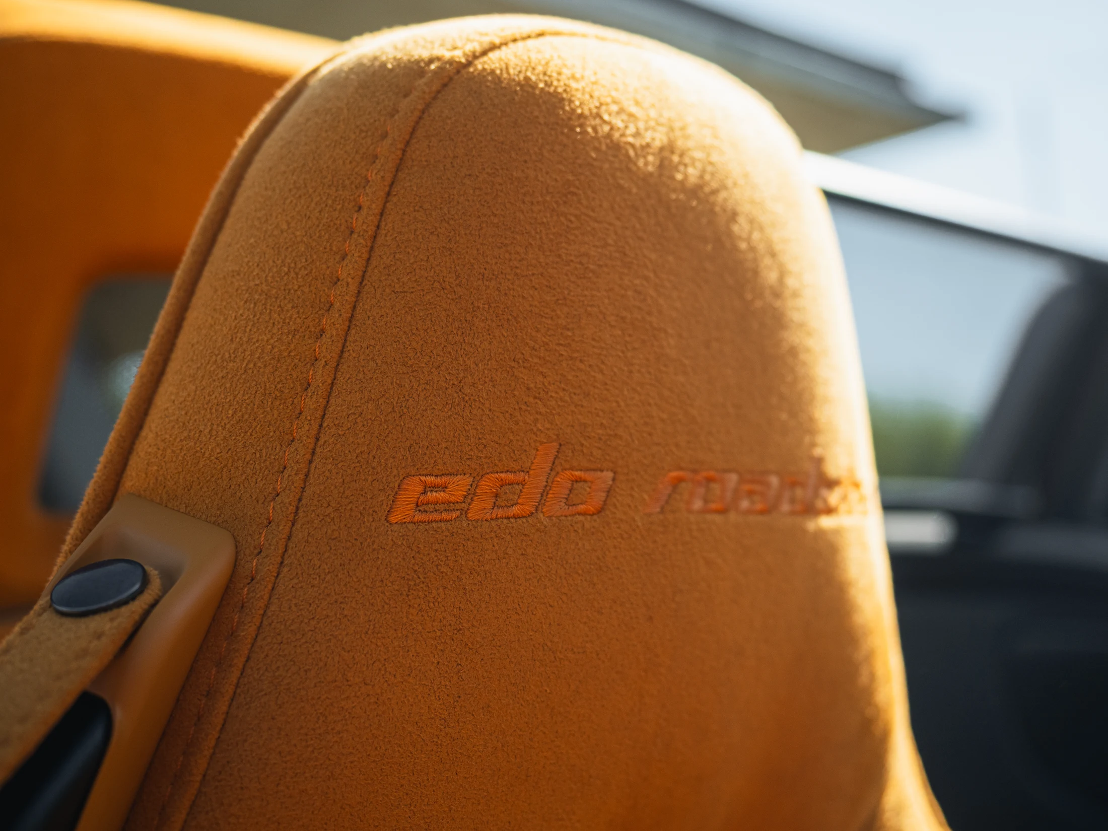 Gestickter edo roadster Schriftzug auf der orangefarbenen Kopfstütze